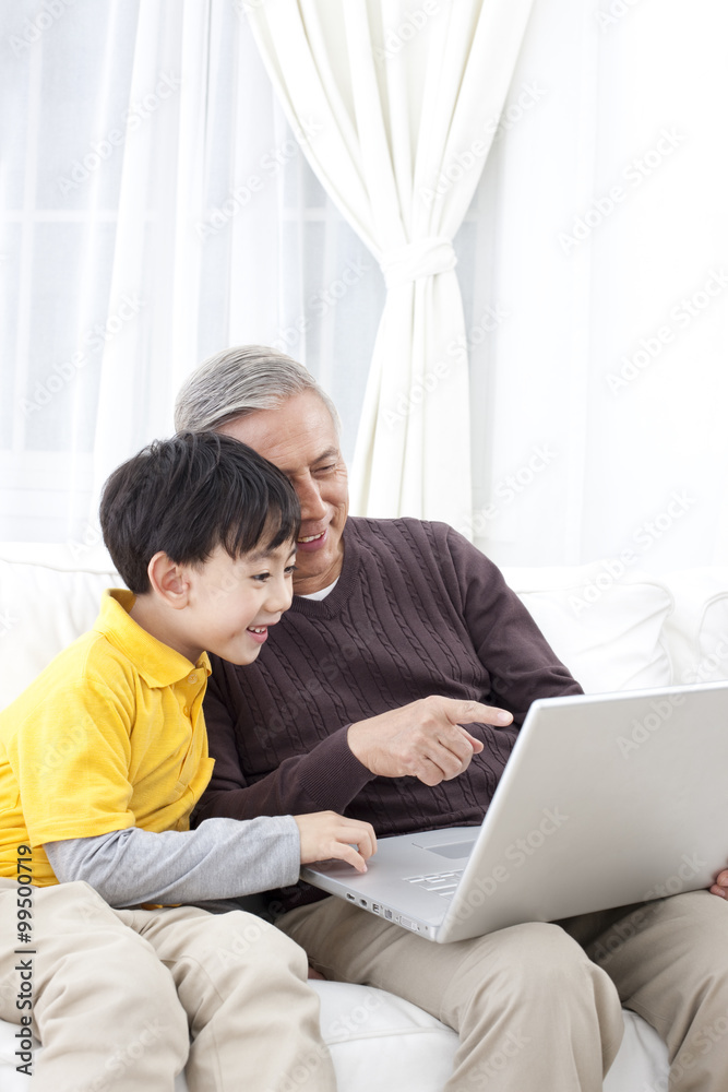 爷爷和孙子使用笔记本电脑