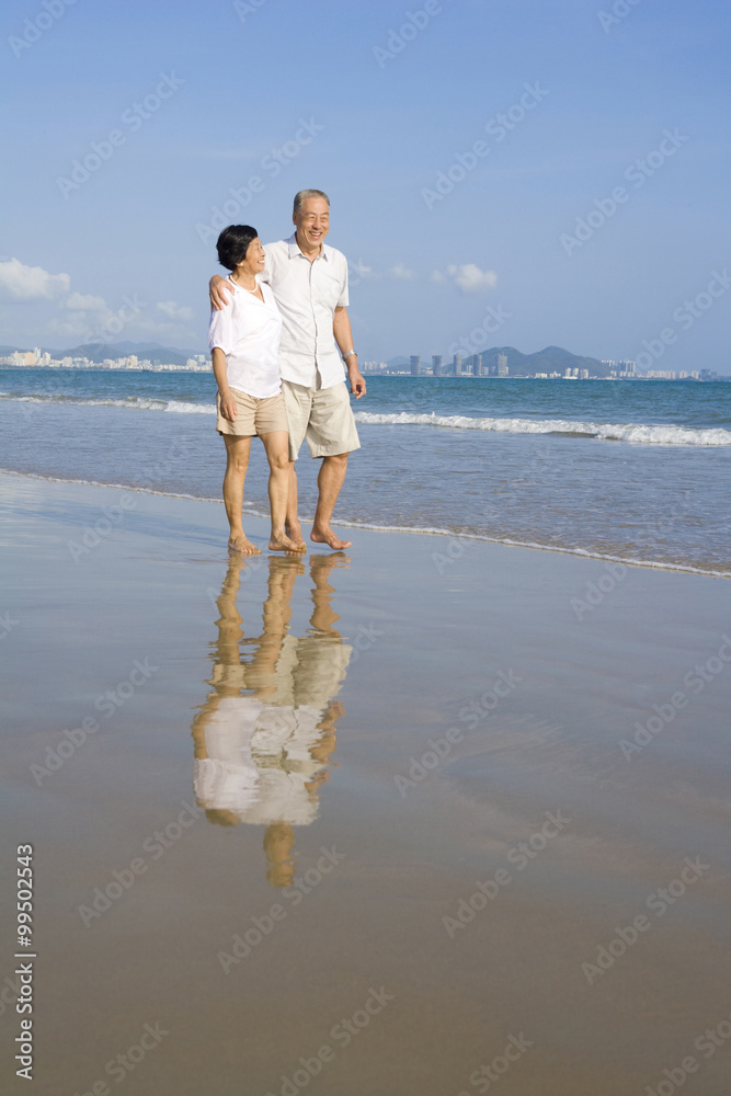 老年夫妇沿着海滩散步