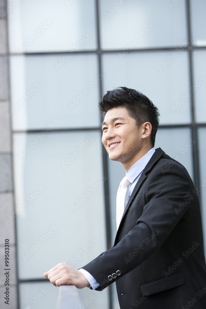 Smiling businessman leaning on the railing