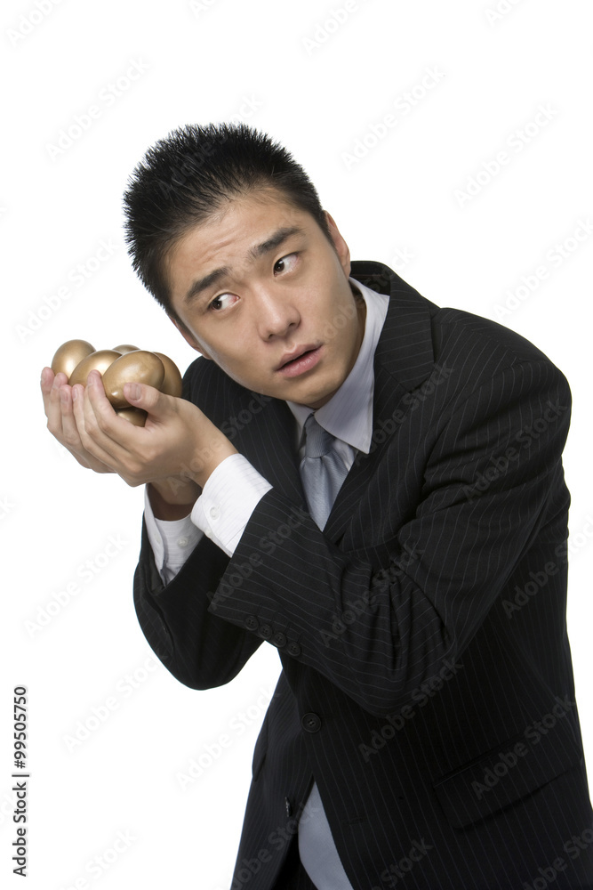 Businessman holding golden eggs 