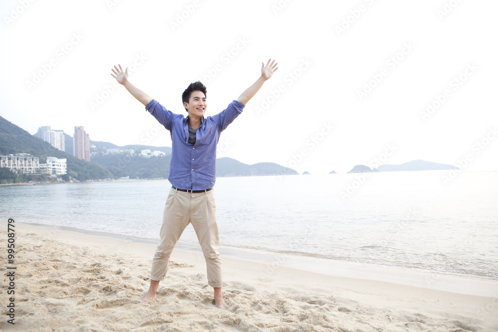 香港浅水湾海滩上，欢快的年轻人张开双臂