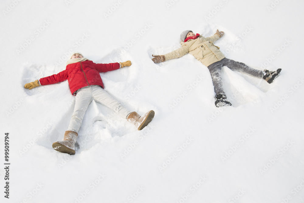 两个孩子在做雪天使