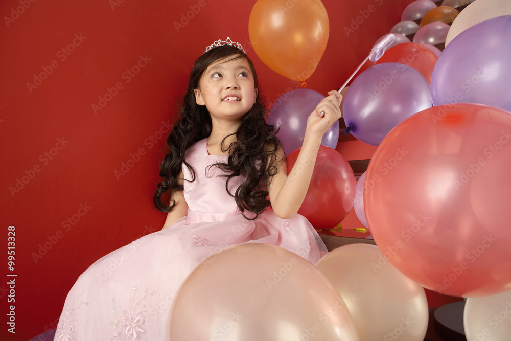 拿着魔杖的女孩拿着气球坐在楼梯上