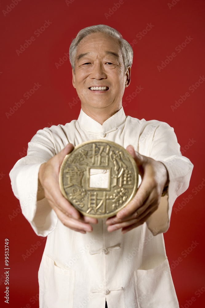 老人手持巨型中国硬币