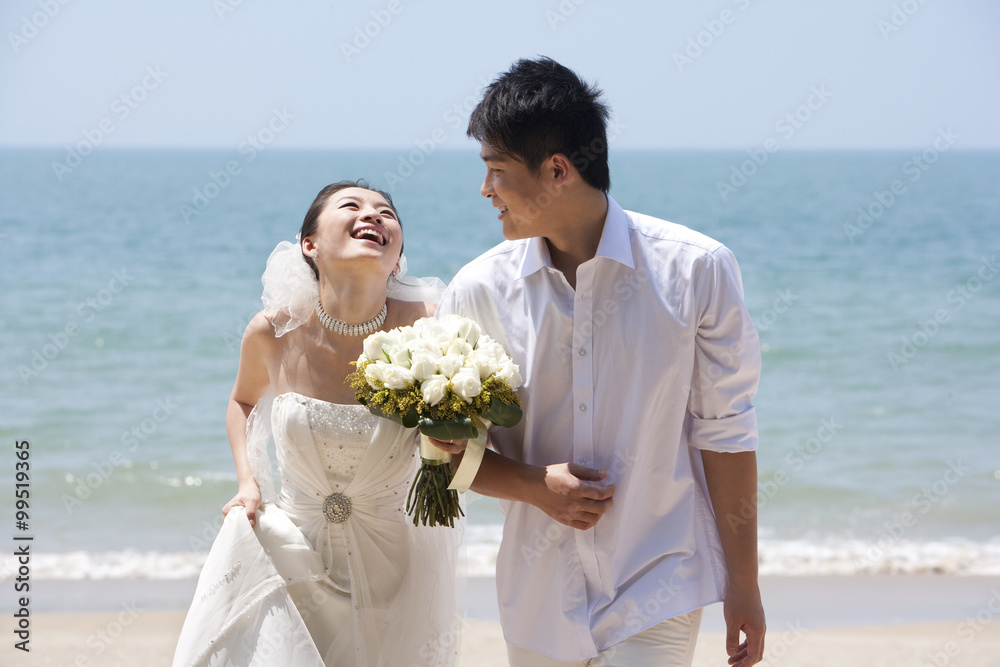 新婚夫妇在海滩上散步