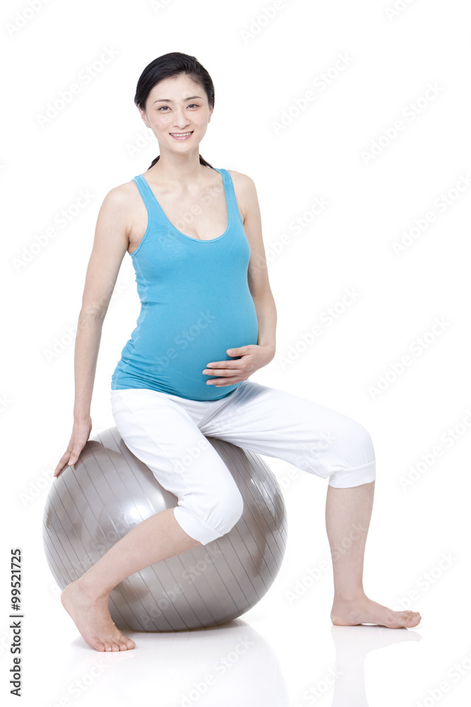 年轻孕妇坐在健身球上
