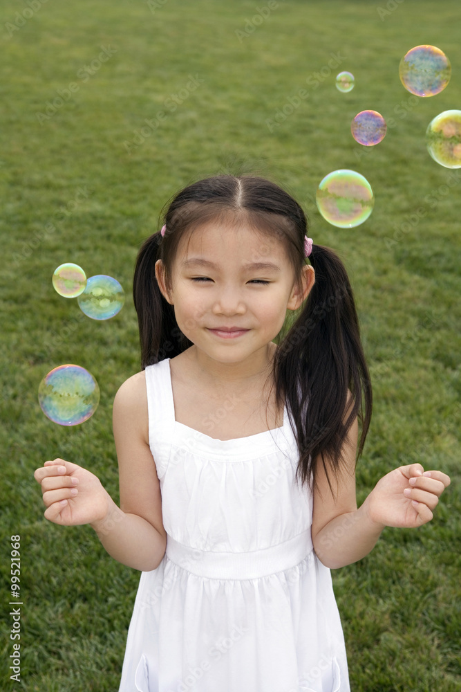 年轻女孩在公园里追逐泡泡