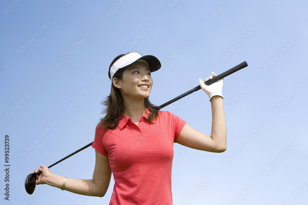 微笑的女高尔夫球手肖像，手里拿着球杆