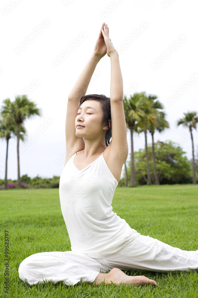 一名女子在草地上练习瑜伽