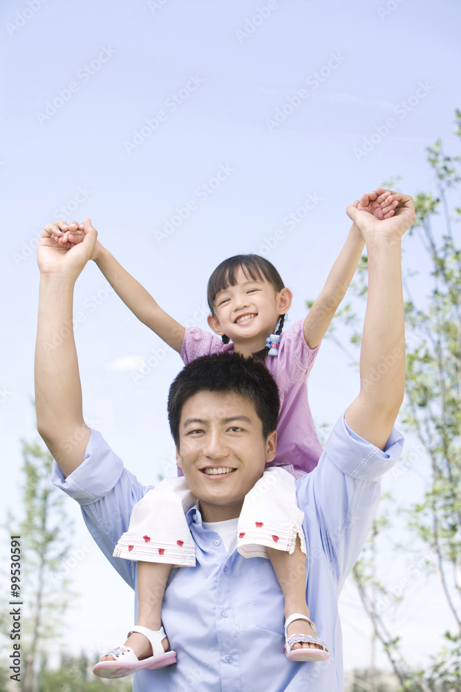 Father carrying daughter on shoulder