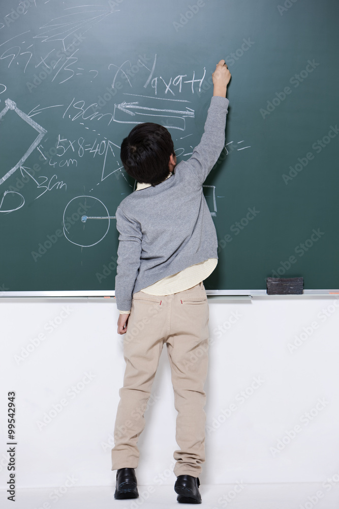 快乐的小男孩在黑板上写字
