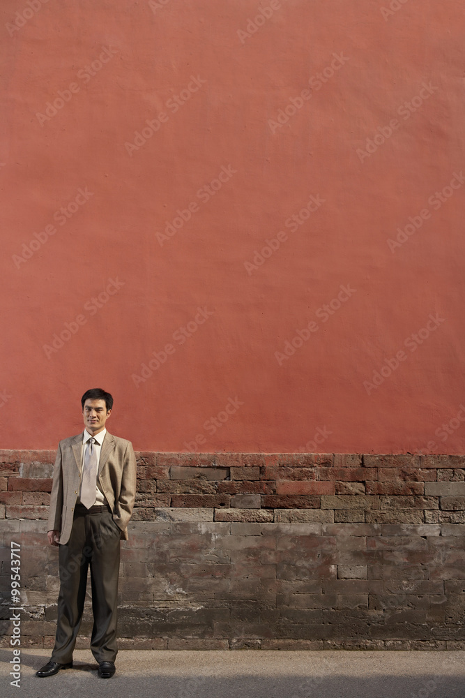 Businessman Standing Against Stone Wall