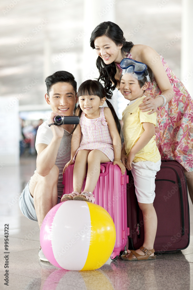 Happy young family photographing at the airport