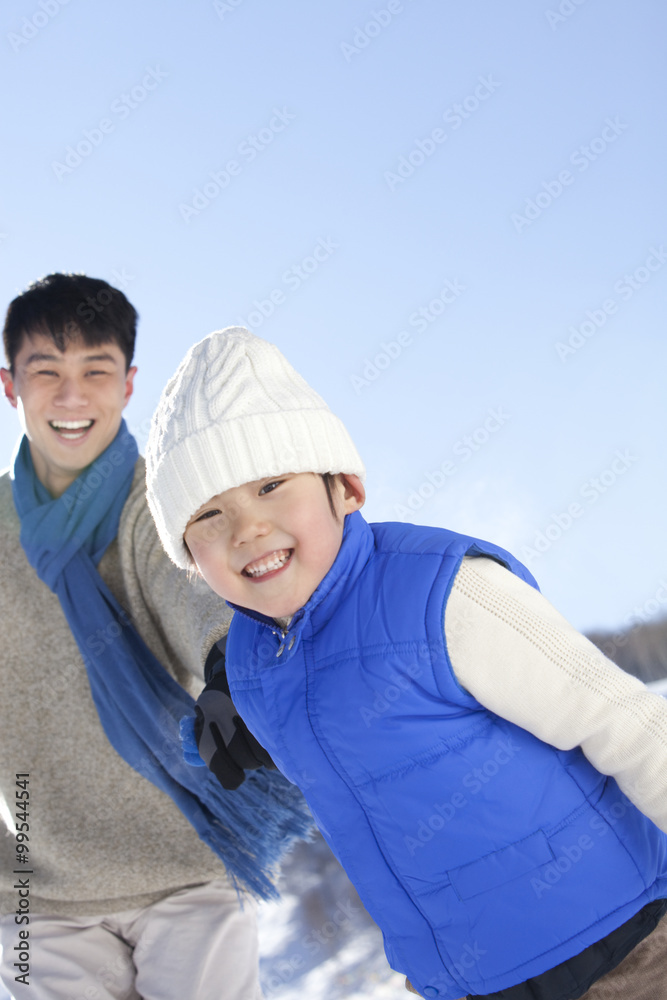父亲在雪地里和儿子玩耍
