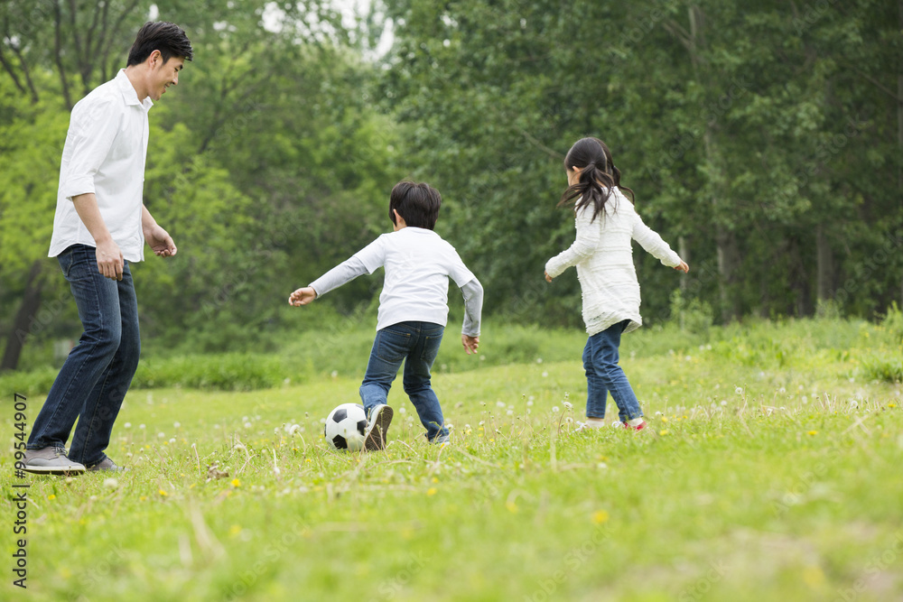 快乐的父亲和孩子们一起踢足球