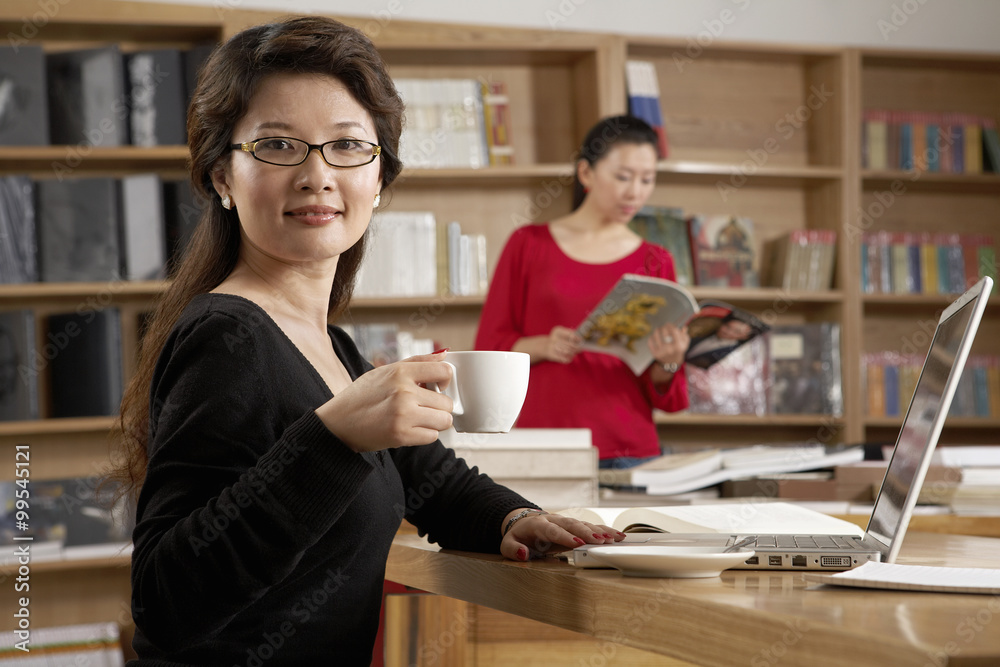 在图书馆享受一杯茶的女人