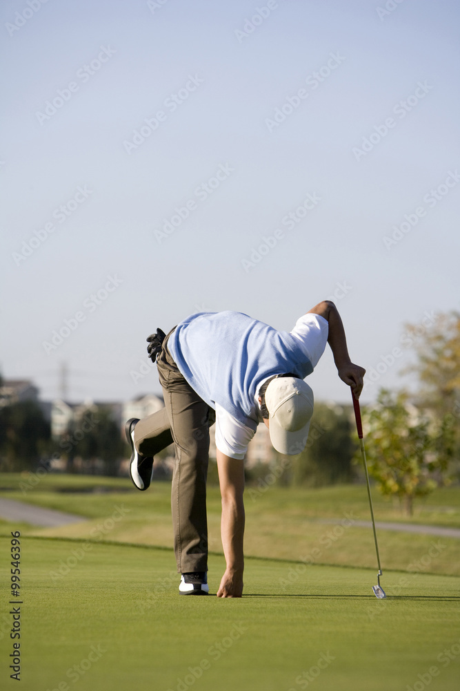 男子从高尔夫球洞捡高尔夫球