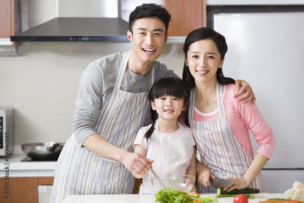 快乐的年轻家庭在厨房烹饪