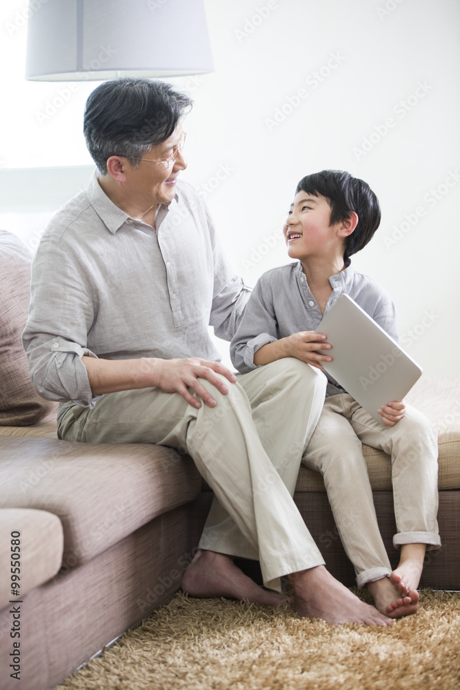 拥有数字平板电脑的快乐爷爷和孙子