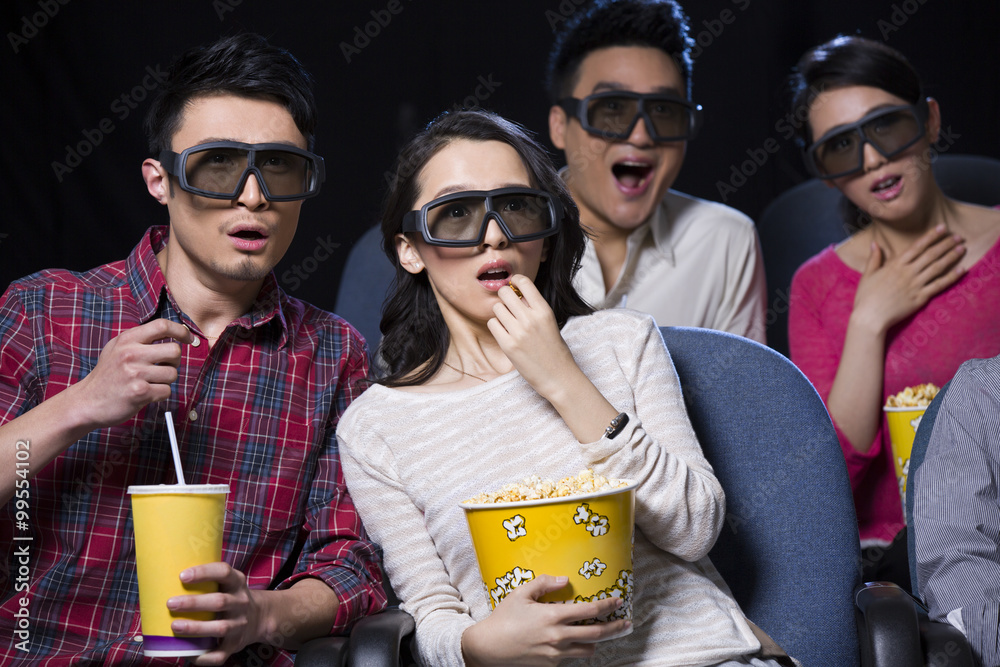 在电影院看3D电影的年轻夫妇
