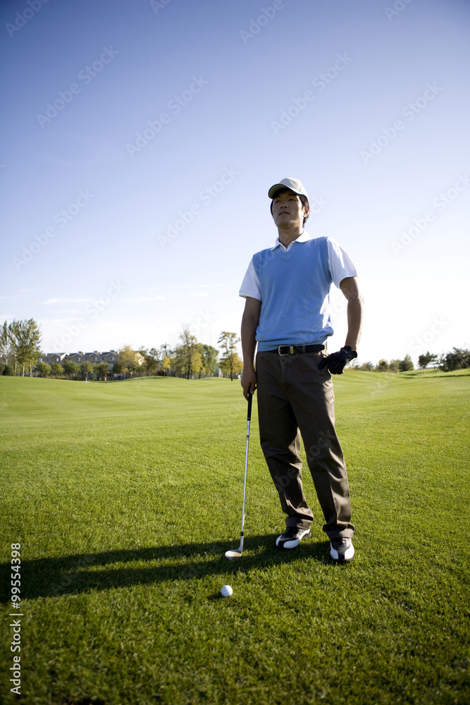 高尔夫球手站在高尔夫球场上
