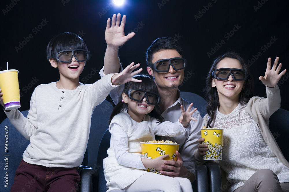 年轻的一家人在电影院看3D电影