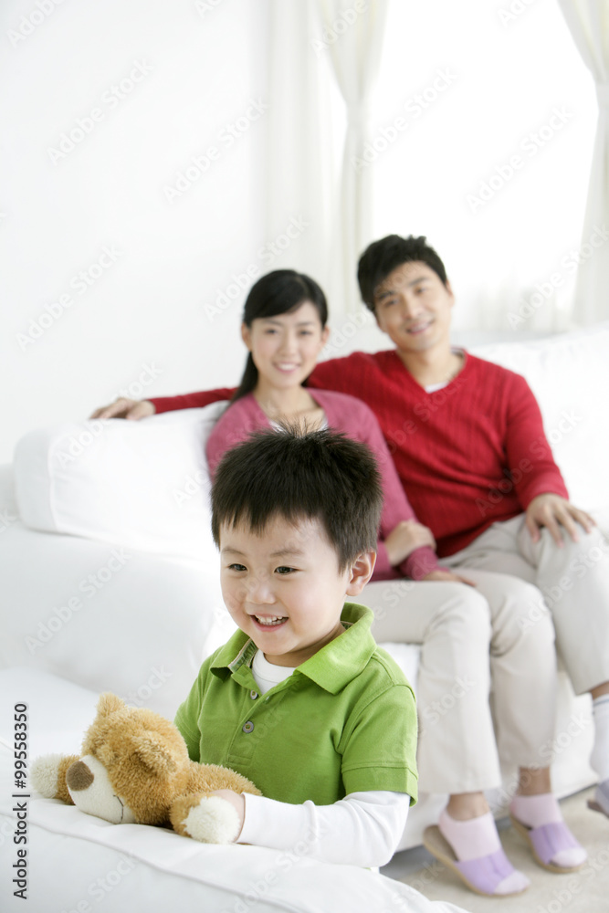 带着泰迪熊和父母的中国小男孩