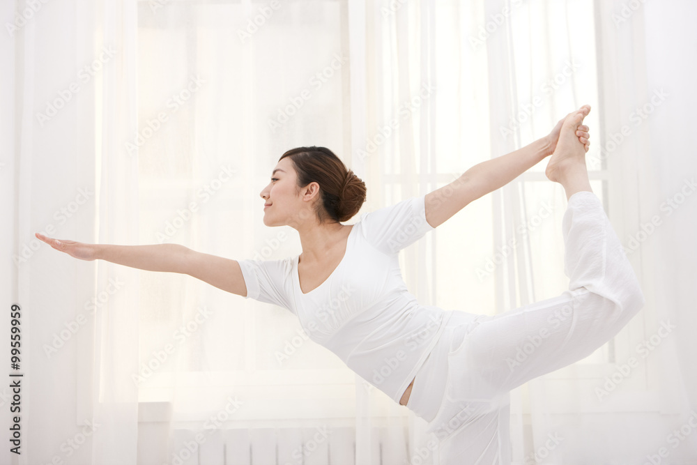 年轻女子伸展和练习瑜伽