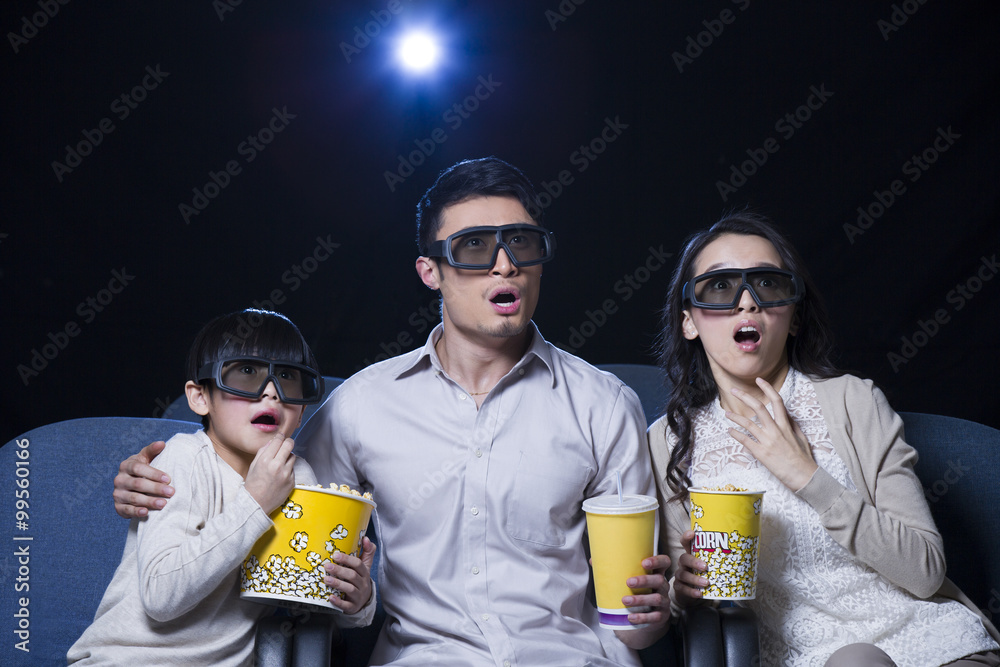 年轻的家庭在电影院观看3D电影