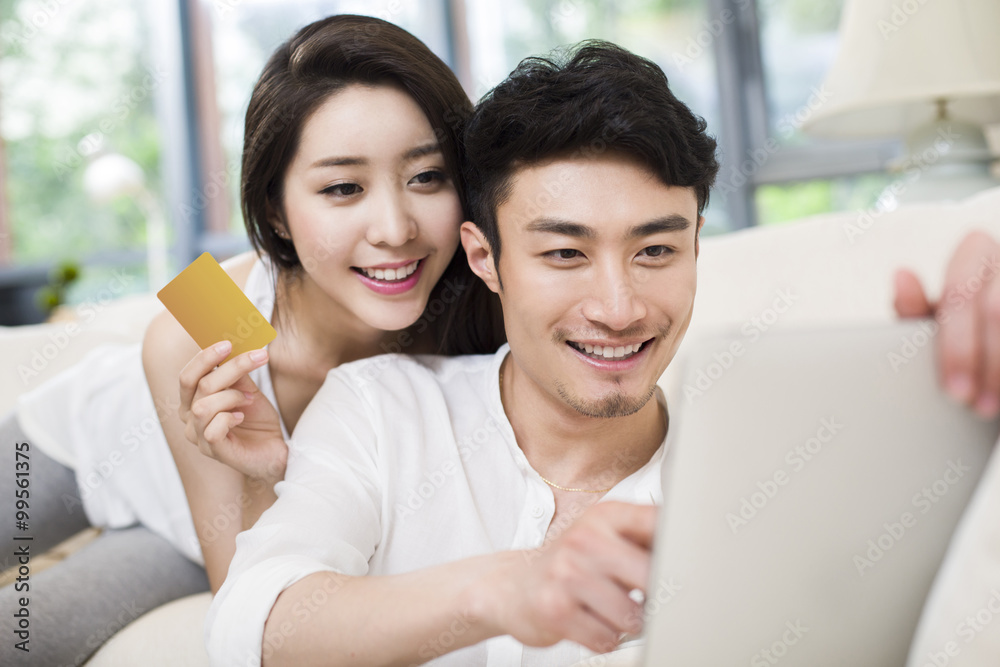快乐的年轻夫妇使用数字平板电脑在线购物