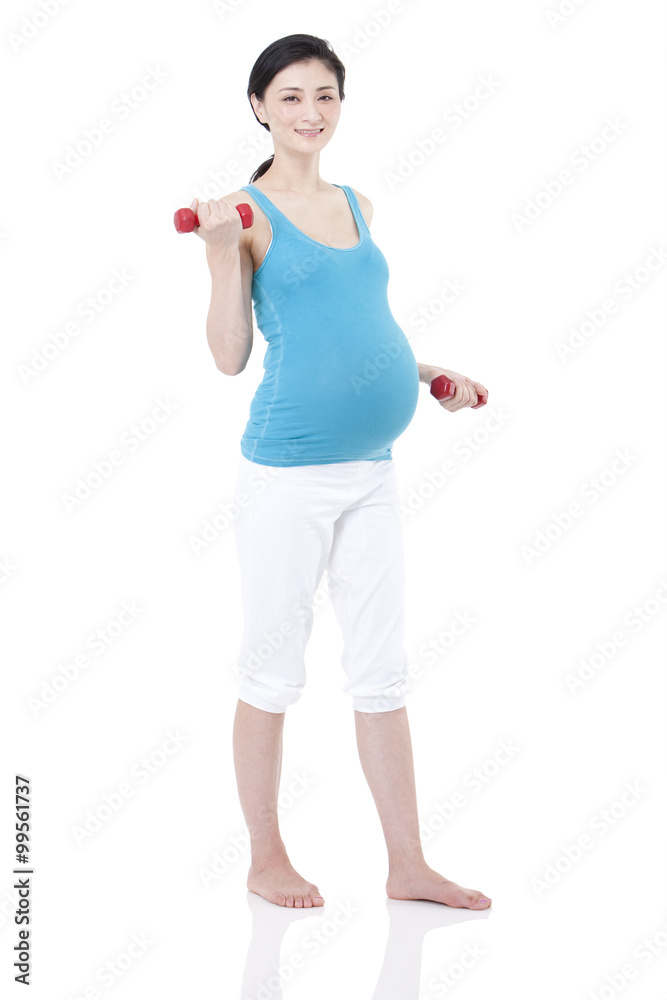 年轻孕妇用哑铃锻炼