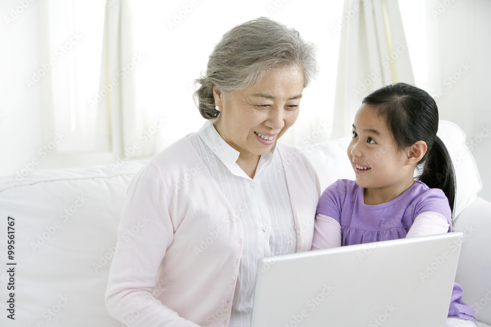 中国祖母和孙女使用笔记本电脑