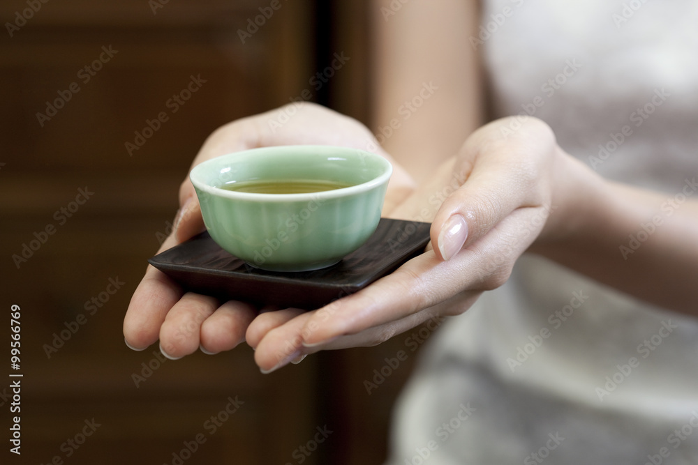 年轻女子端中国茶