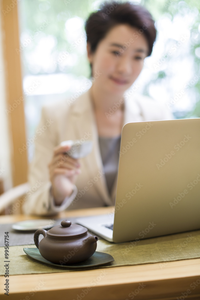 女商人在茶室使用笔记本电脑