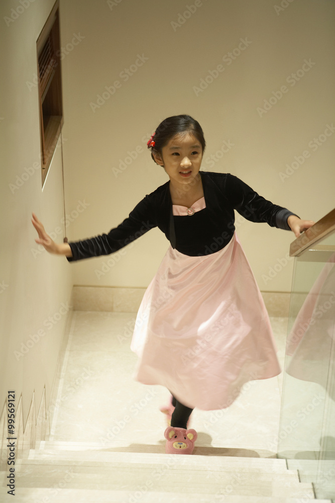 Young Girl Walking Up Staircase Wearing A Party Dress And Pink Fluffy Slippers