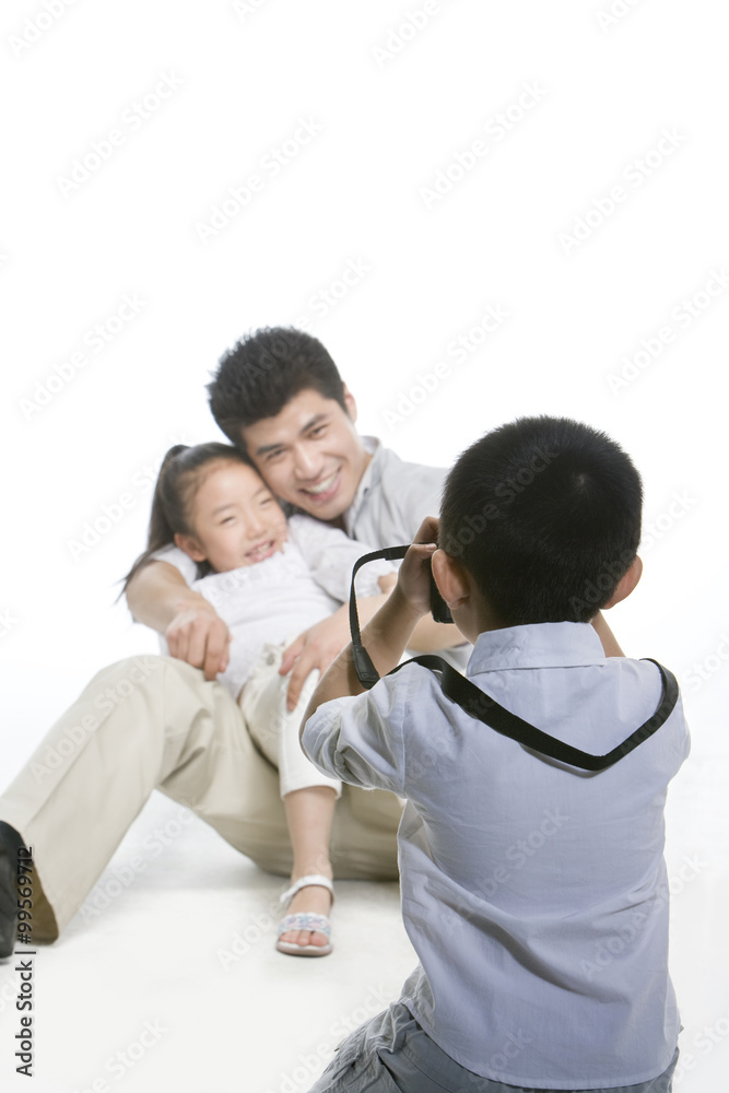 男孩为父亲和妹妹拍照