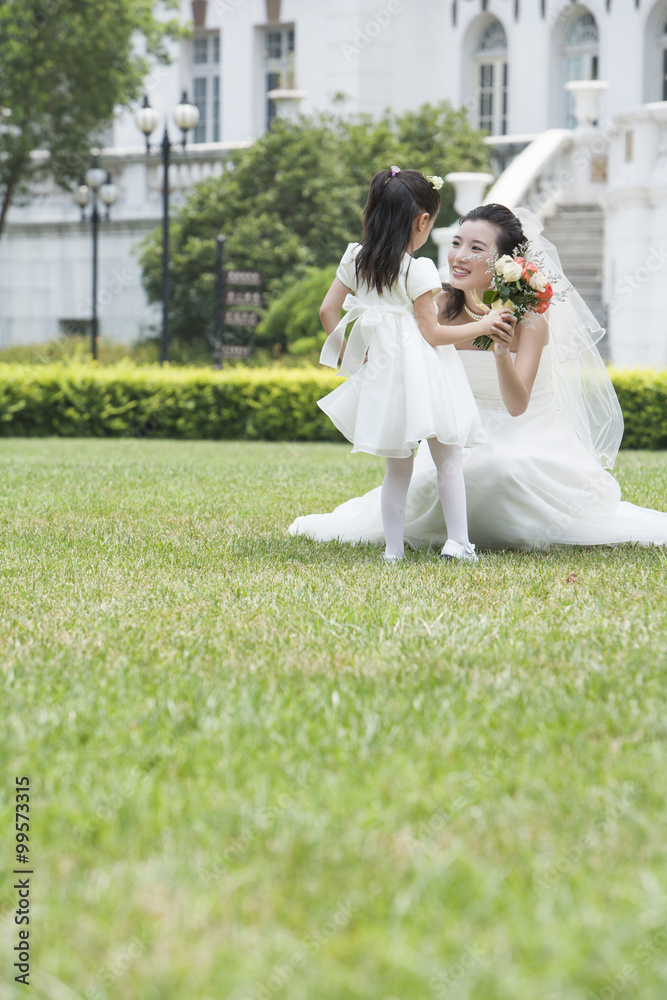A young flower girl with the bride after a wedding