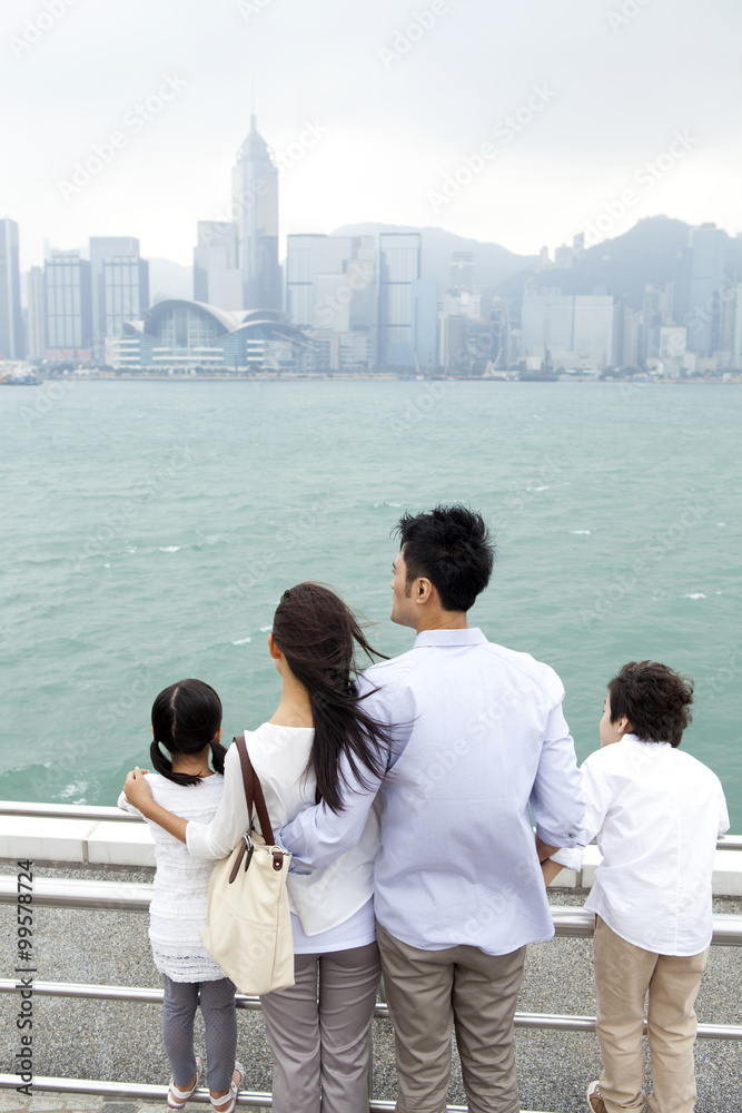 年轻一家人欣赏香港维多利亚港的美景
