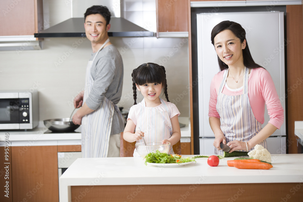 Happy young family cooking in kitchen