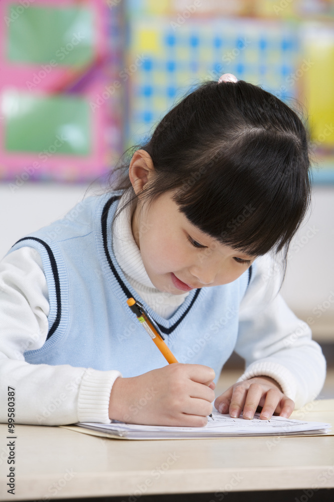 Young student writing in classroom