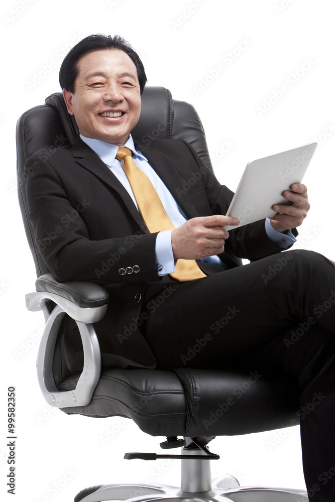 资深商人在董事会椅子上使用数字平板电脑