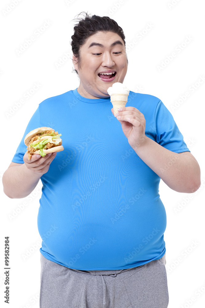 贪婪的胖男人吃汉堡和冰淇淋