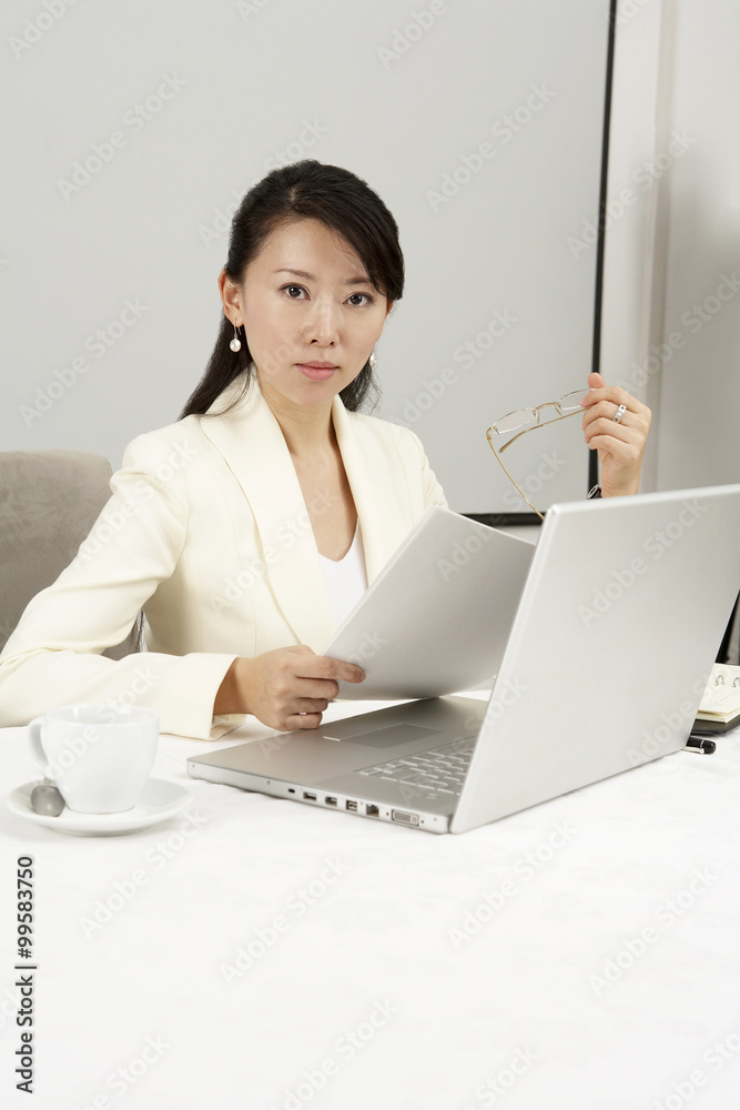 Businesswoman Using Laptop At Dinner Table