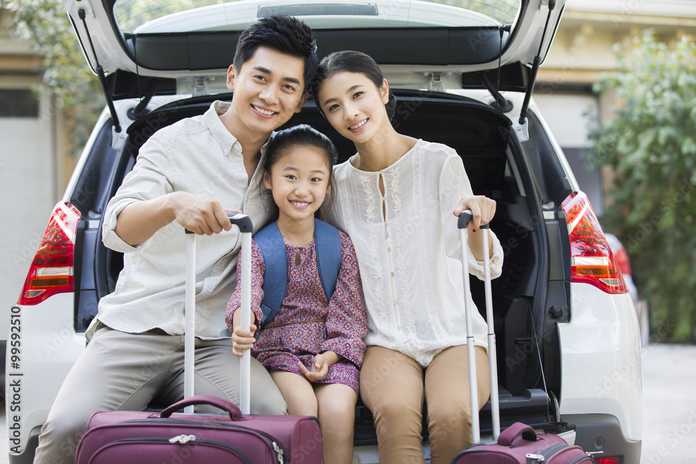 年轻的家庭为汽车旅行打包
