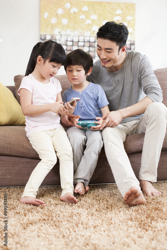 Happy family playing handhold video game in sofa