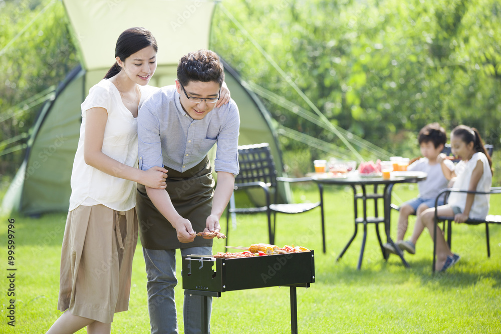 Young family barbecuing outdoors