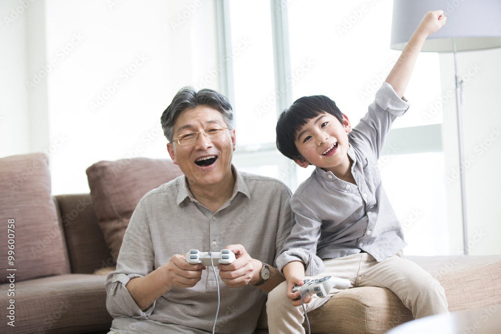 愉快的爷爷和孙子玩电子游戏