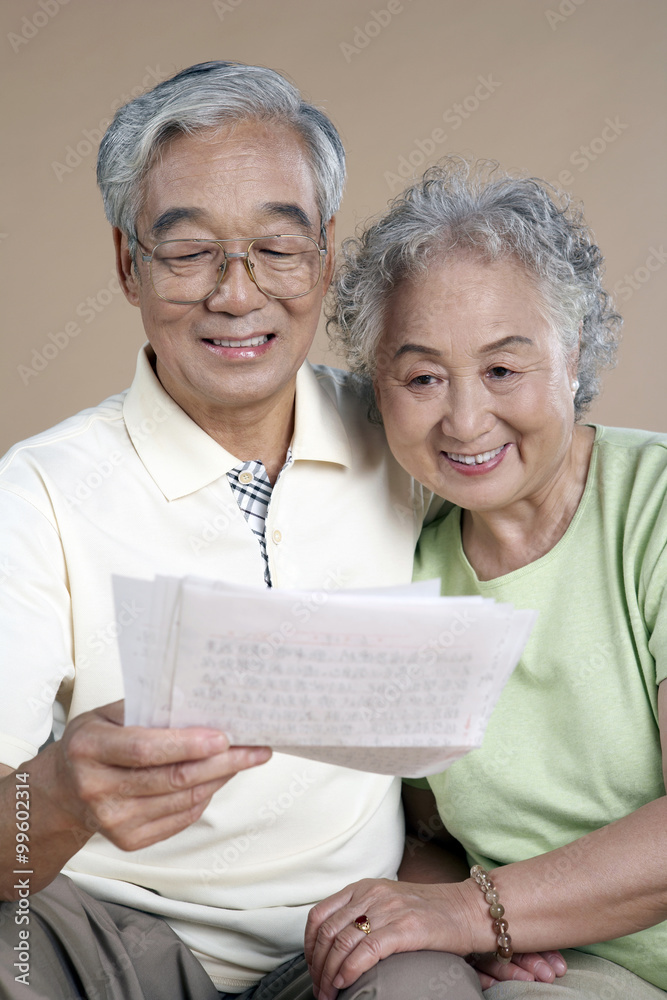 老年夫妇一起读一封信