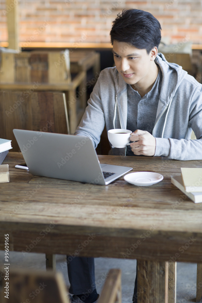 年轻人在咖啡馆使用笔记本电脑
