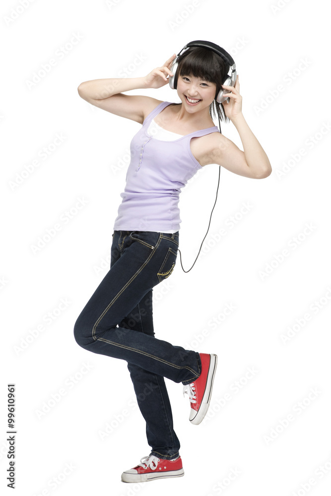 Smiling young woman listening to music on headphones